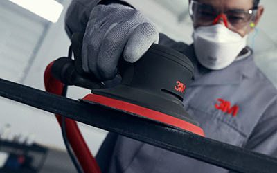 man using xtract to sand metal