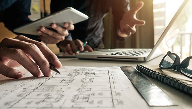 people with hard hats and blueprints