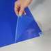 hand peeling blue adhesive floor mat